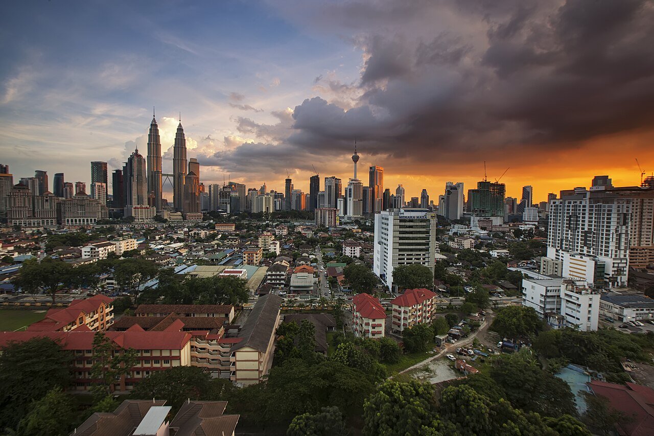 Kuala Lumpur skyline at sunset, with the Petronas Towers and KL Tower